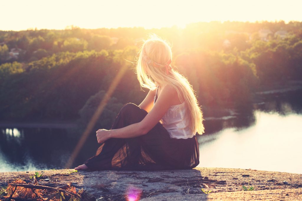 woman sitting on rock
